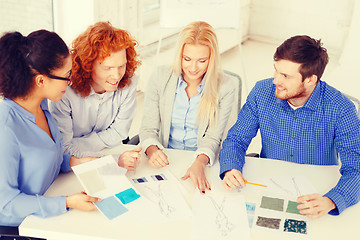 Image showing smiling creative team looking at sketch