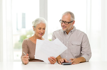 Image showing senior couple with papers and calculator at home