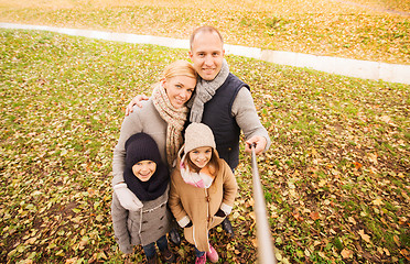 Image showing happy family with selfie stick in autumn park