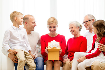 Image showing smiling family with gift at home