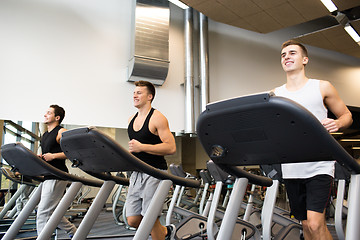 Image showing smiling men exercising on treadmill in gym