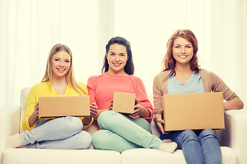 Image showing smiling teenage girls with cardboard boxes at home