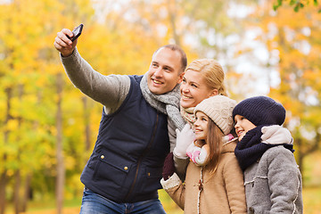 Image showing happy family with camera in autumn park