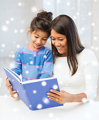 Image showing mother and daughter with book indoors