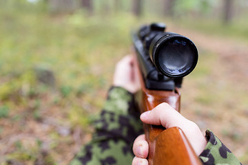 Image showing close up of soldier or hunter with gun in forest