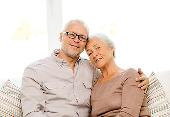 Image showing happy senior couple hugging on sofa at home