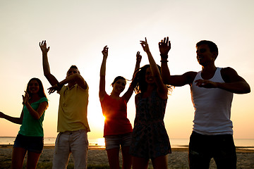 Image showing smiling friends dancing on summer beach