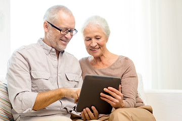 Image showing happy senior couple with tablet pc at home