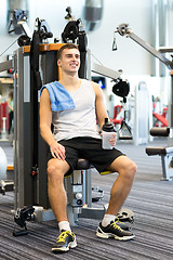 Image showing smiling man exercising on gym machine