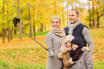 Image showing happy family with smartphone and monopod in park