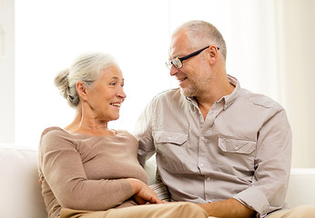 Image showing happy senior couple hugging on sofa at home