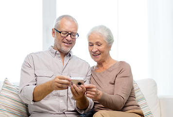 Image showing happy senior couple with camera at home