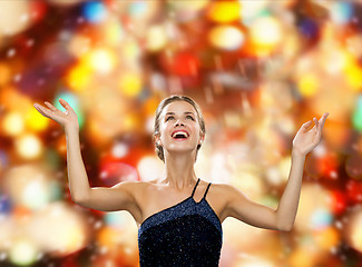 Image showing smiling woman raising hands and looking up