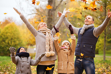 Image showing happy family playing with autumn leaves in park