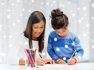 Image showing mother and daughter with coloring pencils indoors