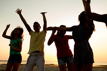 Image showing smiling friends dancing on summer beach