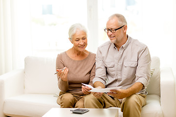Image showing senior couple with papers and calculator at home
