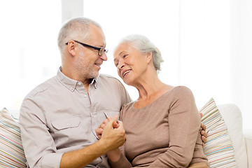 Image showing happy senior couple hugging on sofa at home