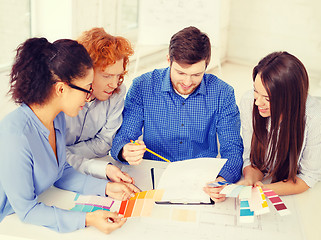 Image showing team with color samples and blueprint at office