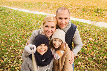 Image showing happy family with selfie stick in autumn park