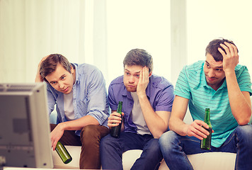 Image showing sad male friends with beer watching sports