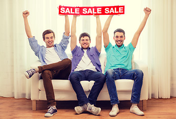 Image showing smiling male friends holding sale sign