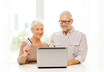 Image showing happy senior couple with laptop and credit card