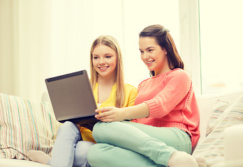 Image showing two smiling teenage girls with laptop at home