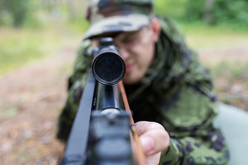 Image showing close up of soldier or hunter with gun in forest