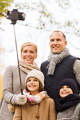 Image showing happy family with smartphone and monopod in park