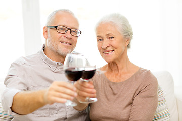 Image showing happy senior couple with glasses of red wine