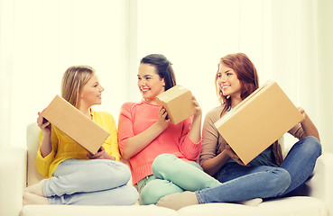 Image showing smiling teenage girls with cardboard boxes at home