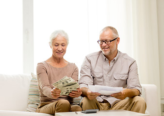 Image showing senior couple with money and calculator at home