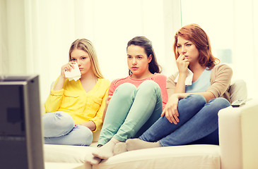 Image showing three sad teenage girl watching tv at home