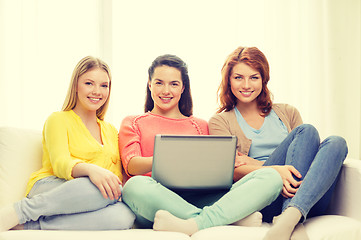 Image showing three smiling teenage girls with laptop at home