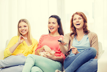 Image showing three smiling teenage girl watching tv at home