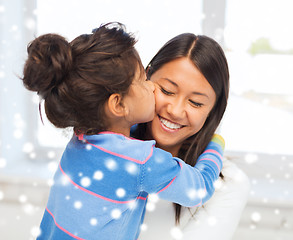 Image showing smiling little girl and mother hugging indoors
