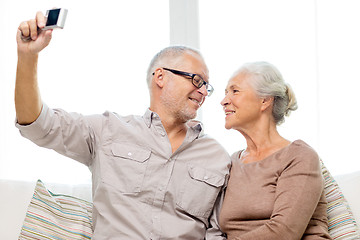 Image showing happy senior couple with camera at home