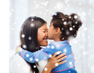 Image showing smiling little girl and mother hugging indoors