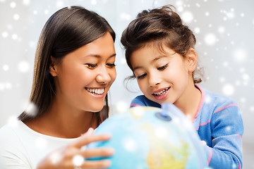 Image showing mother and daughter with globe indoors