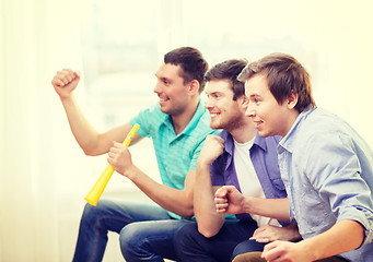 Image showing happy male friends with vuvuzela watching sports