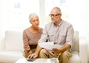 Image showing senior couple with papers and calculator at home