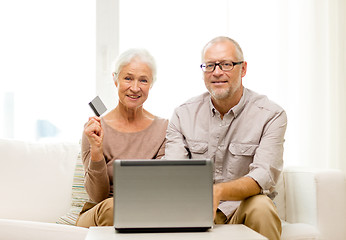 Image showing happy senior couple with laptop and credit card