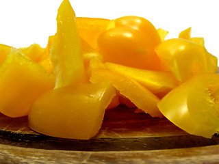 Image showing Slitted yellow pepper on brown wooden plate