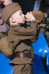 Image showing Young boy in World War 2 uniform drinks water