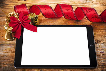 Image showing tablet pc with  christmas decorations on wooden background