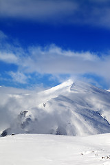 Image showing Off-piste slope and blue sky with clouds at sunny day