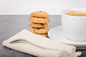 Image showing Cup of coffee with cookies and spoon on table