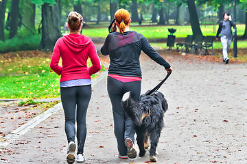 Image showing Two teenage with dog