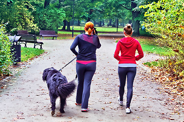 Image showing Two teenage with dog